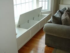 a living room filled with furniture next to a white window sill and wooden flooring