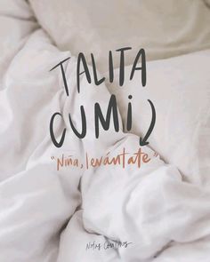 an unmade bed with white sheets and the words talita cumi written on it