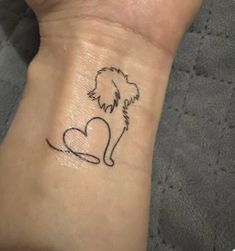 a small dog with a heart tattoo on the wrist