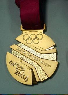 a gold medal with a red ribbon hanging from it's side on a table