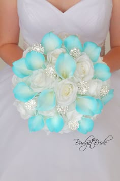 the bride's bouquet is made up of white roses and blue calla lilies