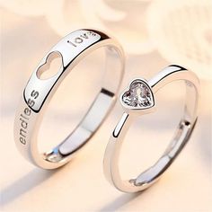 two silver rings with hearts and i love you written on the sides, one has a diamond