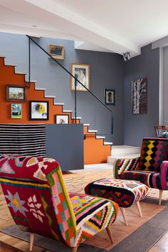 a living room filled with lots of furniture next to a stair case in front of a window