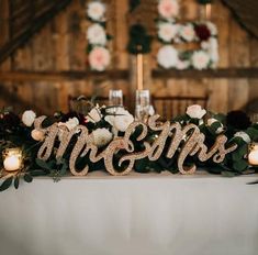 a table topped with candles and flowers next to a sign that says mr and mrs