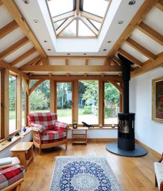 a living room filled with furniture and a wood burning stove in the middle of it