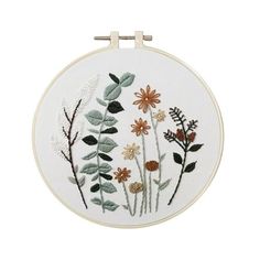 a white embroidery hoop with flowers and leaves on it