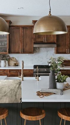 a kitchen with two pendant lights over the island