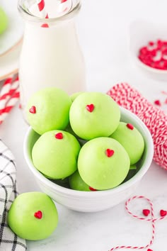 green macaroni and cheese balls in a white bowl with red hearts on them