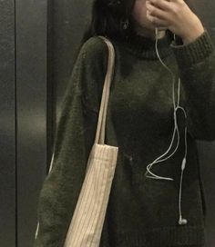 a woman taking a selfie with her cell phone in front of an elevator door