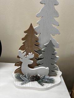 a wooden christmas tree sitting on top of a white table