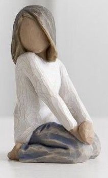 a small figurine sitting on the ground with her hands behind her back and legs crossed