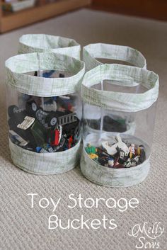 two clear storage containers filled with toys on the floor