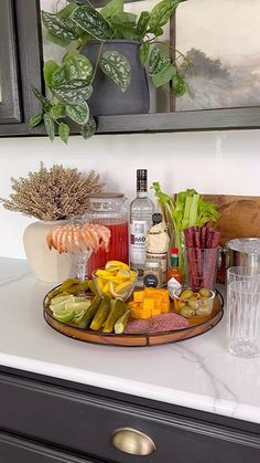 a tray filled with drinks on top of a counter next to glasses and other items