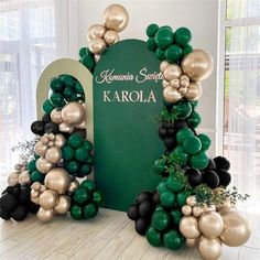 an arch made out of balloons with the letter k in gold, black and green