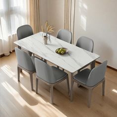 a dining room table with six chairs and a bowl of fruit on the table in front of it