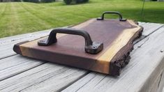 a piece of wood sitting on top of a wooden table next to a green field