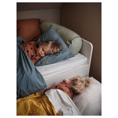 two young children sleeping on top of a bed