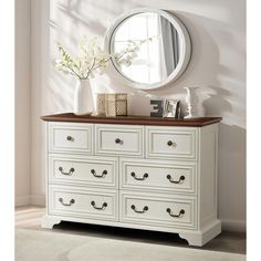 a white dresser with drawers and a mirror