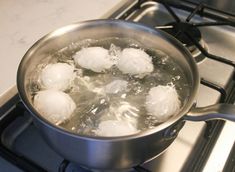 boiling water in a pot on the stove with ice cubes and eggs inside it