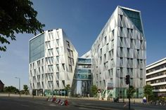 two large white buildings sitting on the side of a road