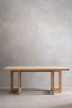 a wooden table sitting on top of a white carpeted floor next to a wall