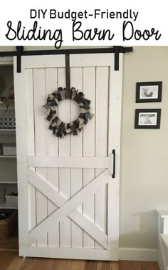 a white barn door with a wreath hanging on the side and text overlay that reads diy budget - friendly sliding barn door