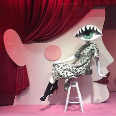 a woman sitting on top of a stool next to a giant fake monster's mouth