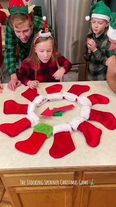 a group of people sitting around a table making christmas decorations