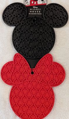 two mickey mouse shaped cookie pans on top of a white towel with red and black circles