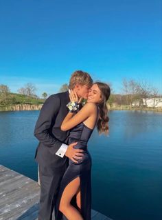 a man and woman are hugging on a dock