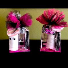 two bottles with pink and white yarn in them sitting on top of a table next to each other