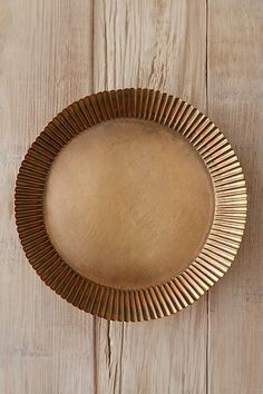 a gold plate sitting on top of a wooden table