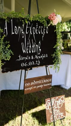 a sign that is sitting on top of a easel with plants growing out of it