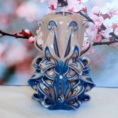 a blue and white vase sitting on top of a table next to a tree branch