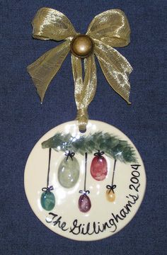 a ceramic ornament with three ornaments hanging from it's side on a blue background