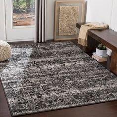 an area rug in a living room with a bench and chair next to the door