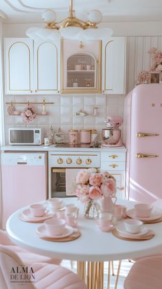 a white table with pink chairs and plates on it next to a stove top oven