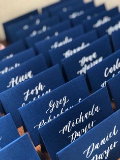 blue place cards with white calligraphy on them