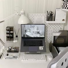 a laptop computer sitting on top of a white desk