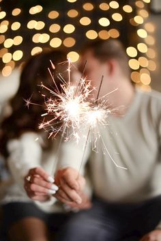 a man and woman holding sparklers in their hands