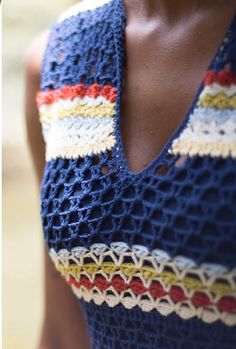 a woman is wearing a crocheted top with an open v - neckline