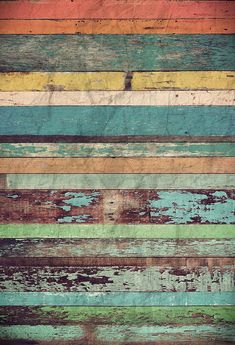 an old wooden wall with multicolored paint