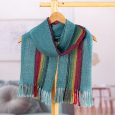 a green scarf hanging on a clothes rack