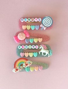 three different types of hair clips on top of a pink surface with hearts and candy