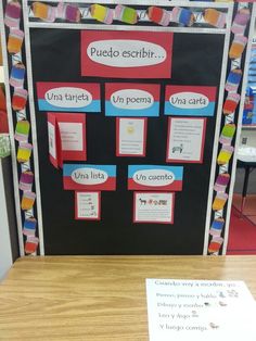 a bulletin board with spanish words and pictures attached to it on a table in a classroom