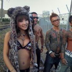 a group of people standing next to each other in front of a chain link fence