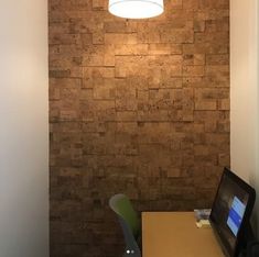 a room with a desk and chair next to a wall that has a stone pattern on it