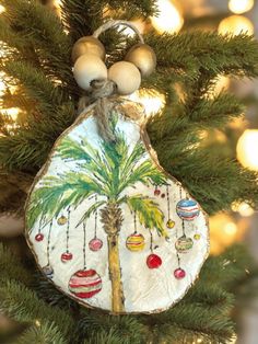 an ornament hanging from a christmas tree with ornaments on it's side