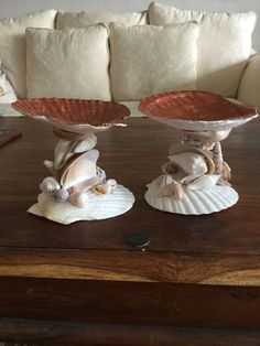 two seashells sitting on top of each other in front of a white couch