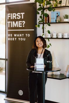 a woman standing at a podium in front of a sign that reads first time? we want to meet you